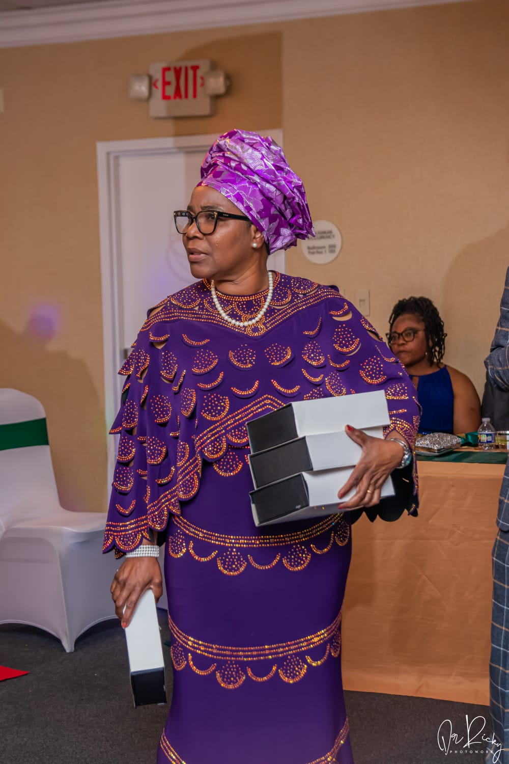 Member in traditional Togolese attire holding awards